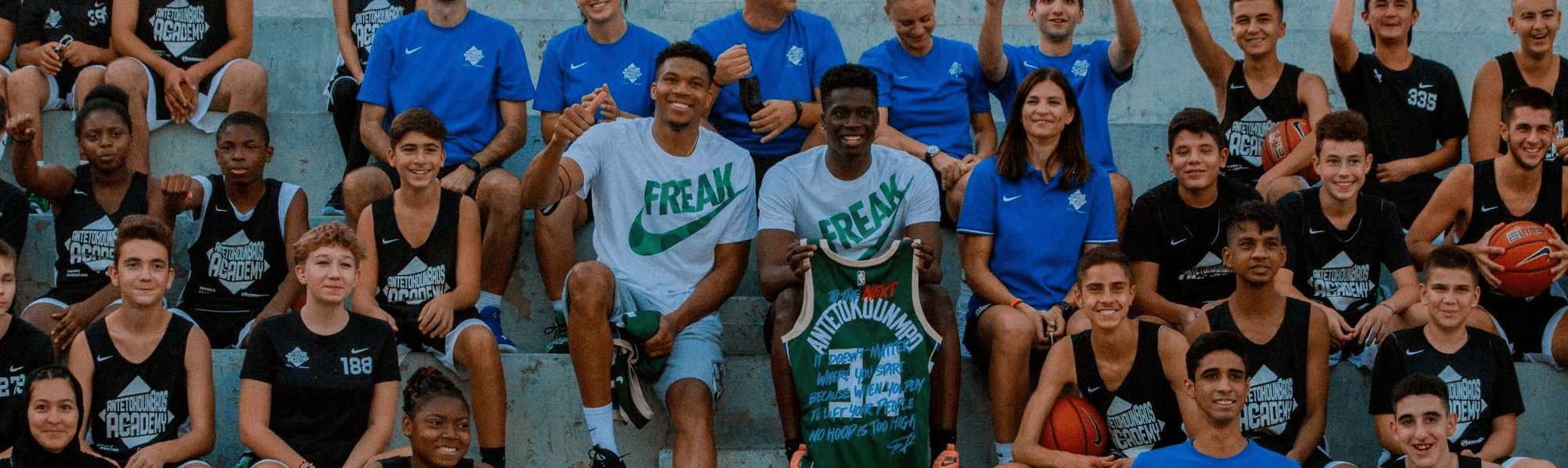 Giannis Antetokounmpo and his academy sat in a basketball court stand
